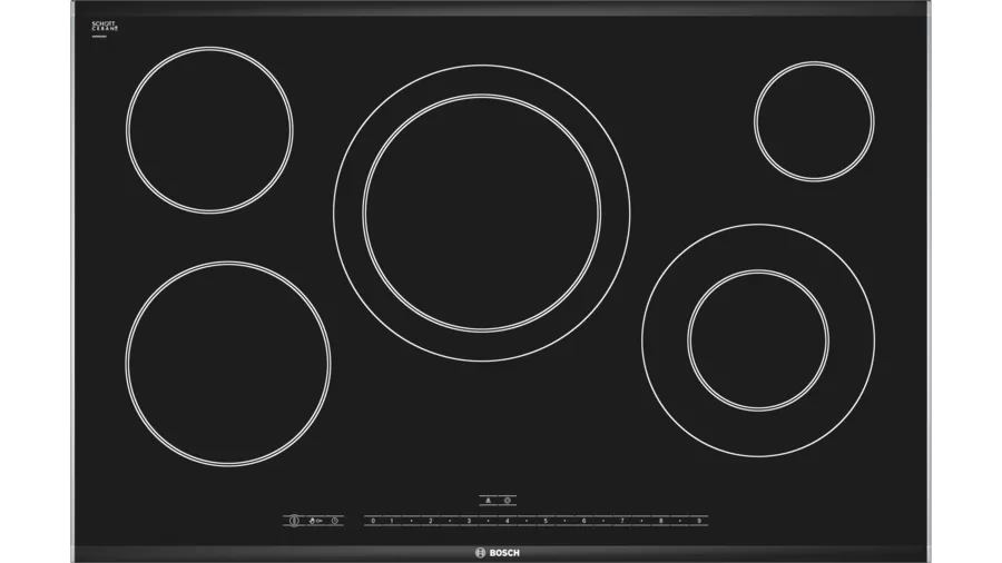 Cocina de vitrocerámica elegante y moderna en una cocina bien iluminada de Denia, destacando su diseño liso y contemporáneo que facilita la cocción y limpieza.
